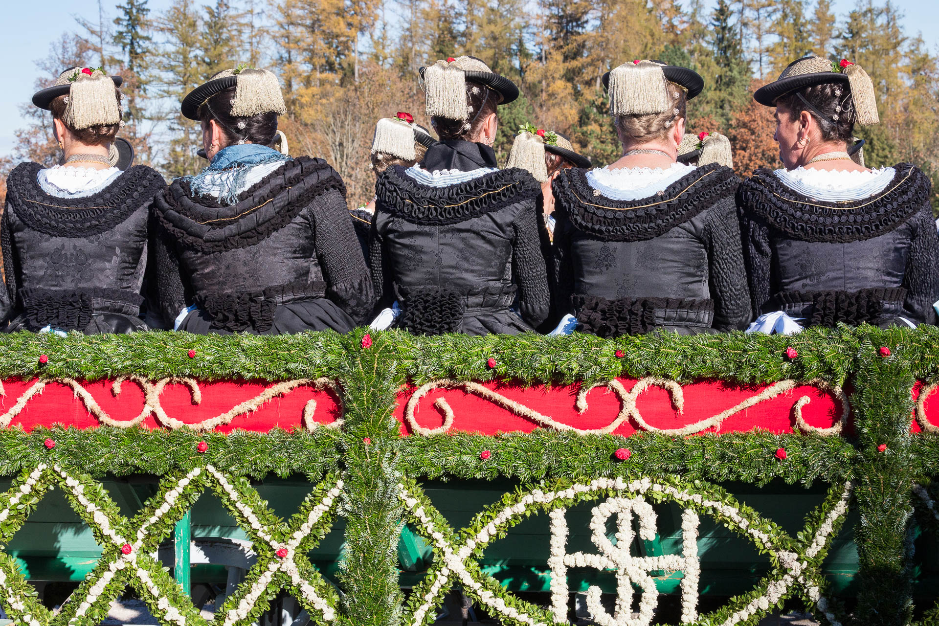 Frauen in bayerischer Tracht im Kastenwagen sitzend von hinten fotografiert. Reportagefotografie - Fotoreportage von photo-genic.