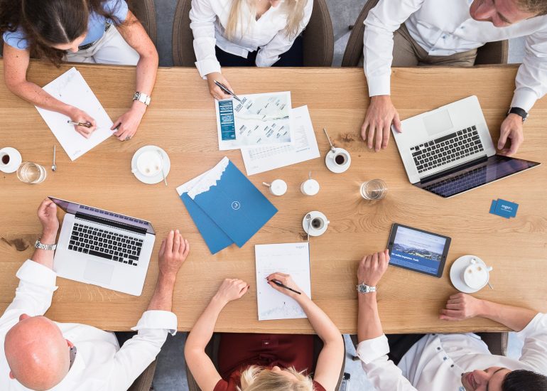 Portfolio Businessfotografie: Mitarbeiter Teammeeting - Draufsicht auf Besprechungstisch