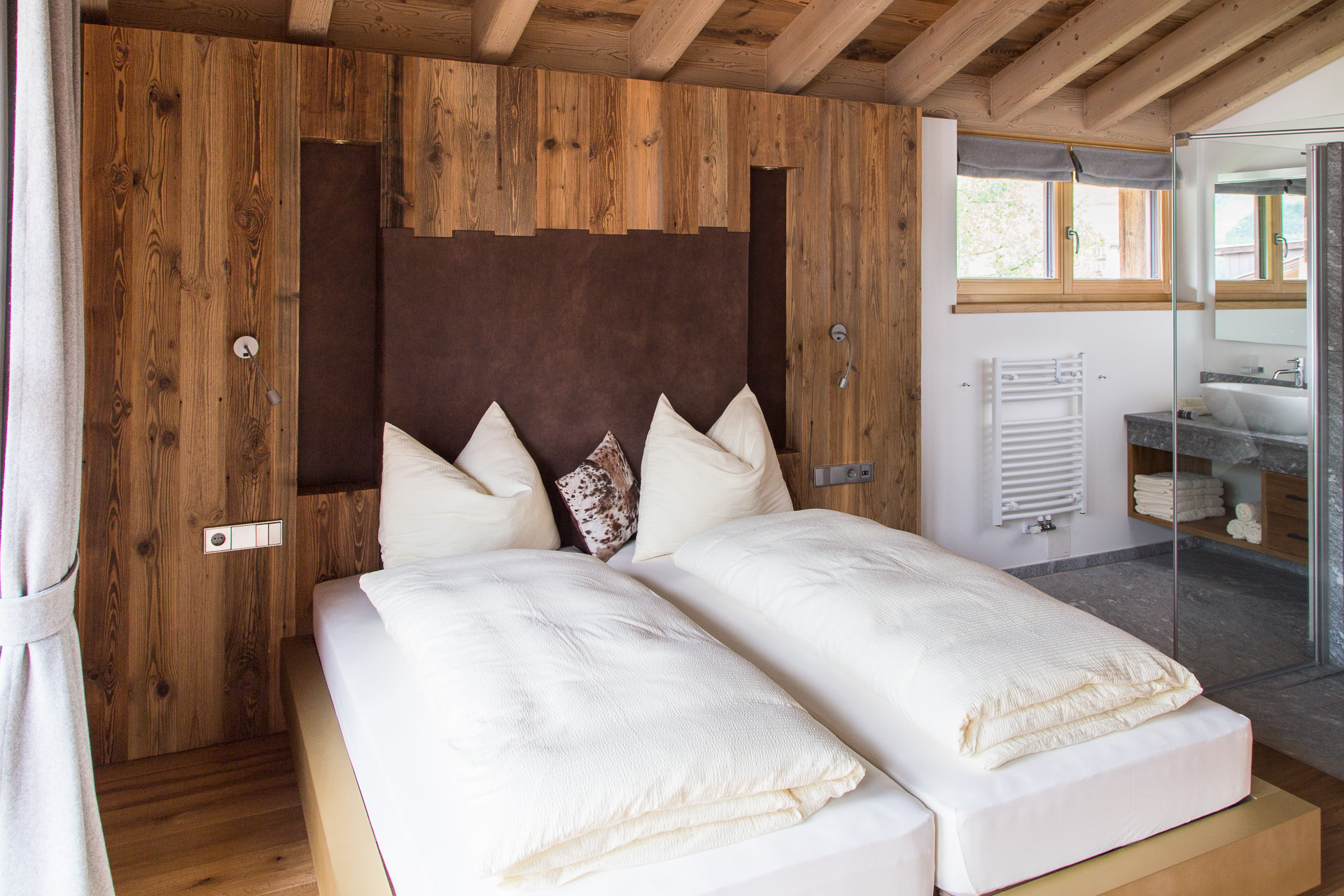 Hotelfotografie: Schlafraum mit Doppelbett und offenen Bad im Chalet St. Vigilio