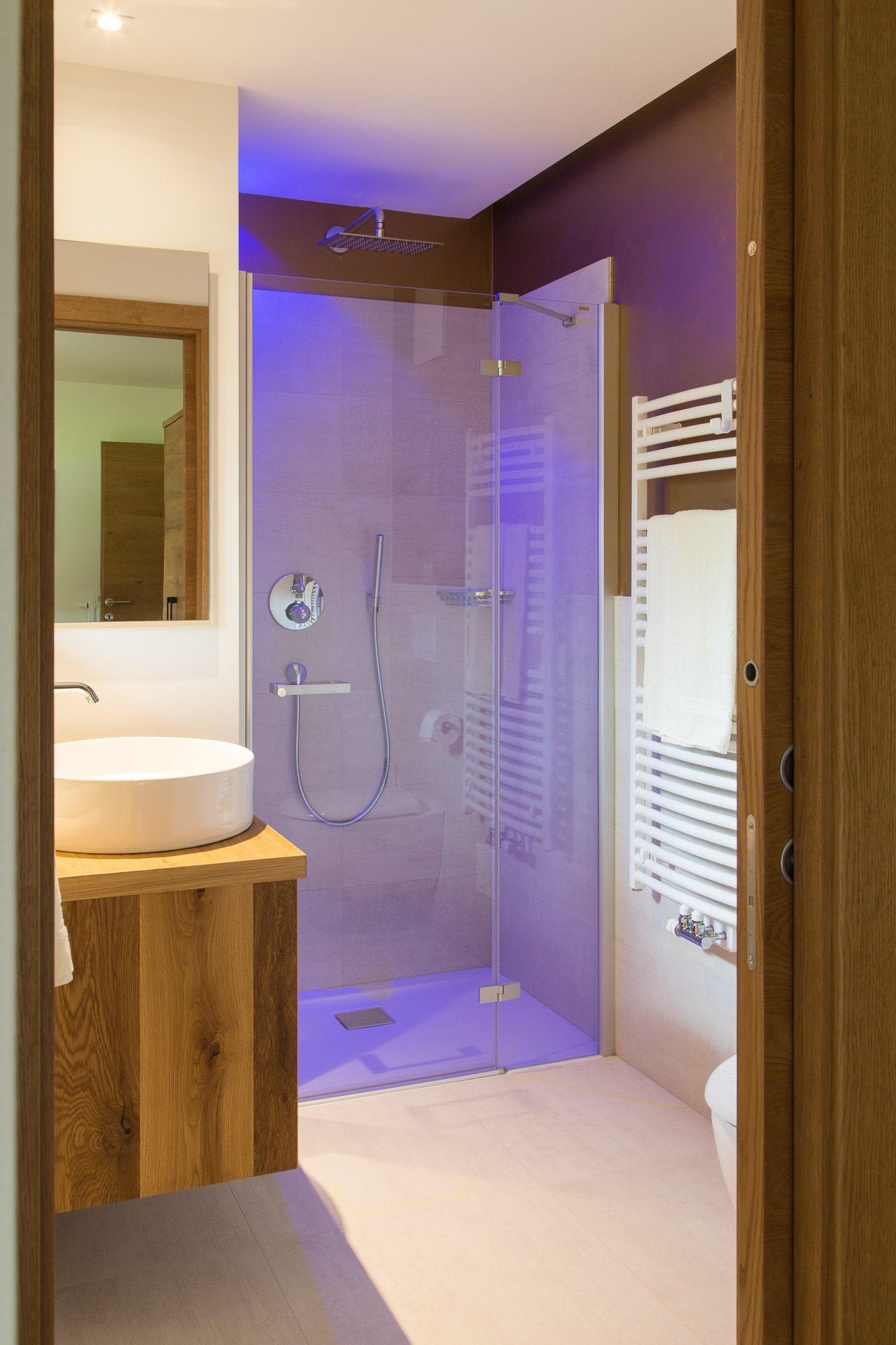 Ferienwohnung: Blick in das Bad. Die Dusche ist mit violetten Licht ausgeleuchtet
