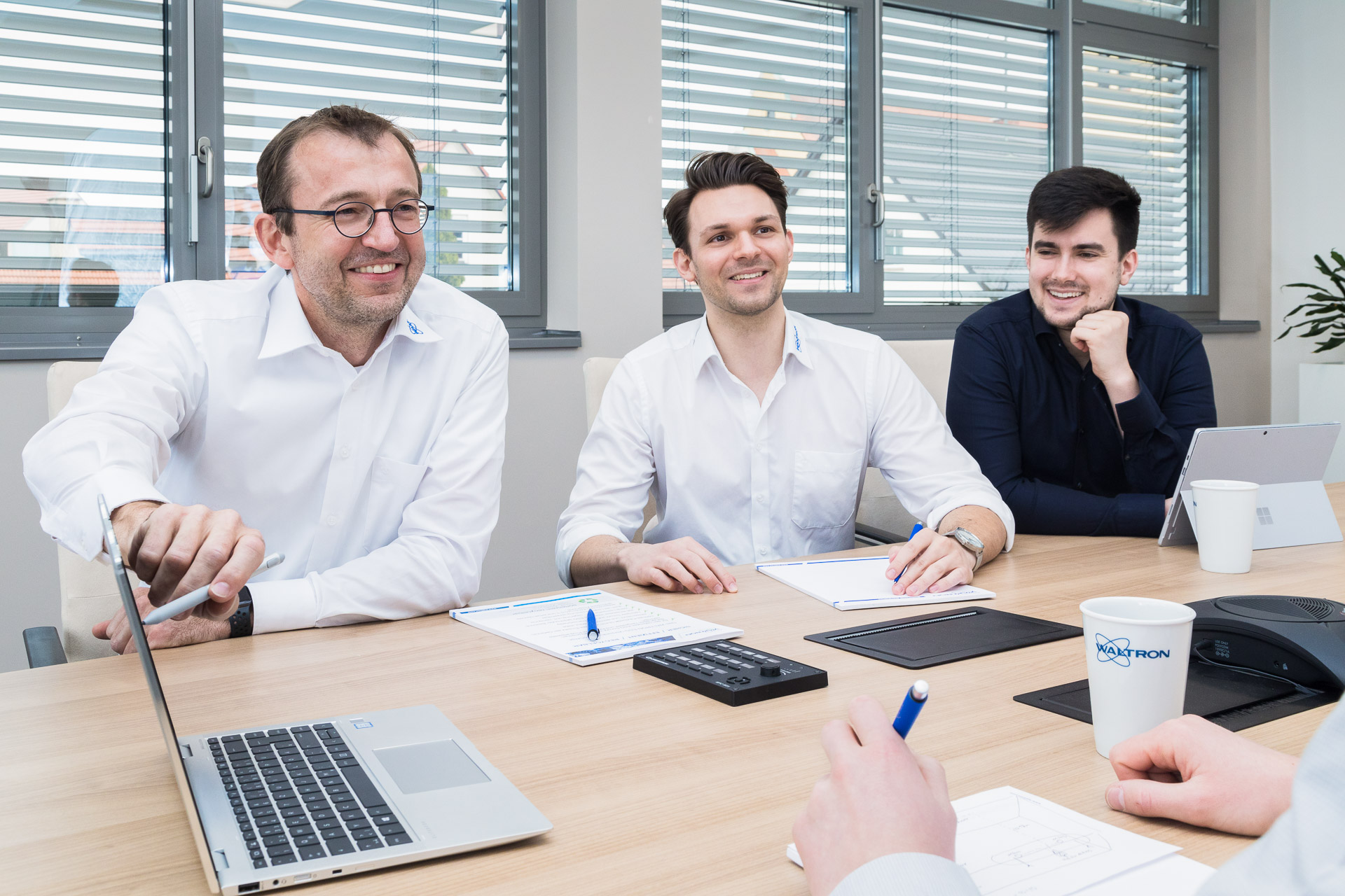 Businessfotografie: Meeting, Kollegen sitzen am Besprechungstisch bei guter Stimmung